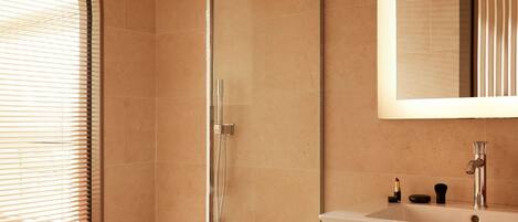 A bathroom with a shower, a sink, and a mirror.