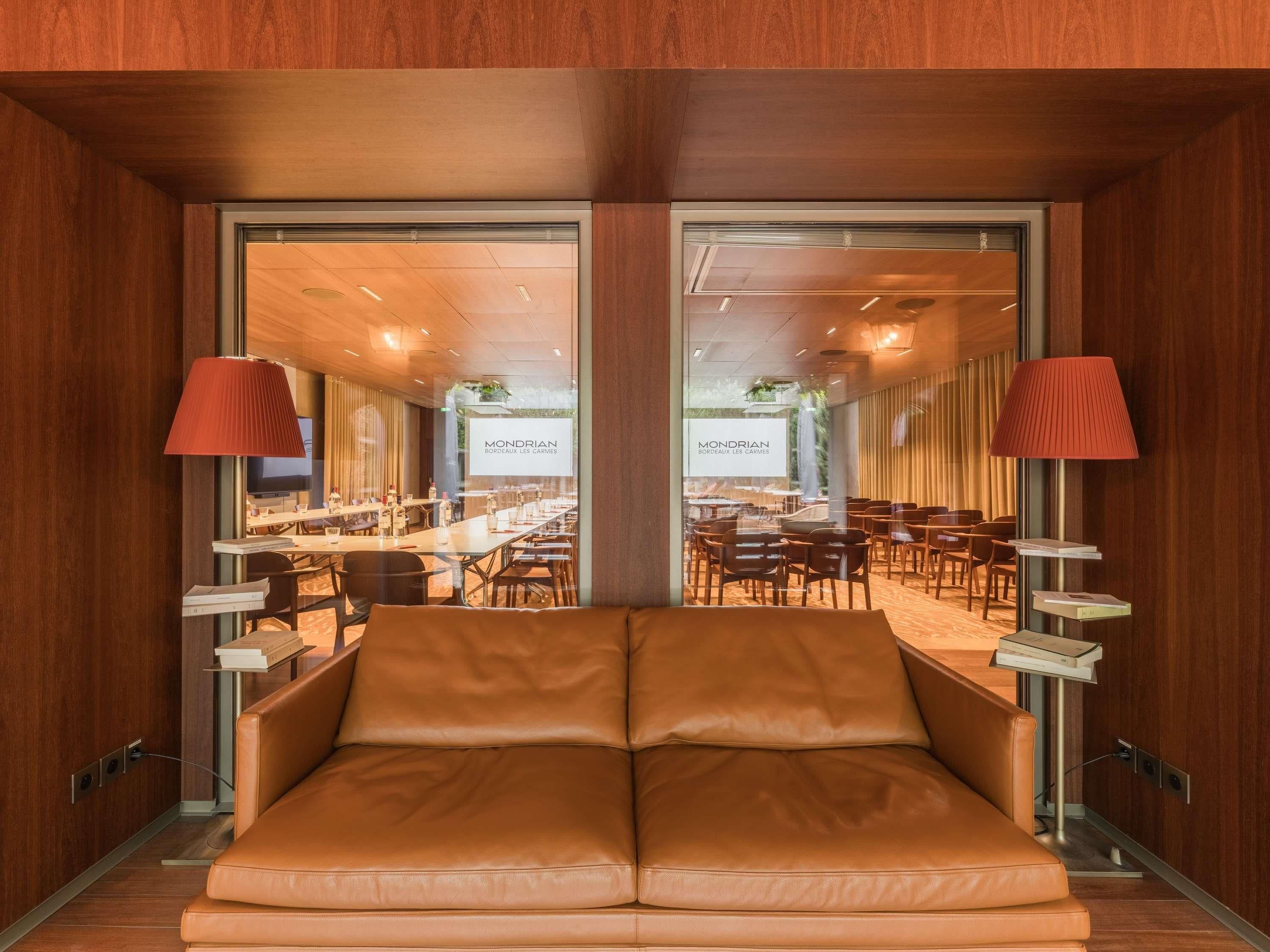 Ein Hotelzimmer mit großem Fenster, einer Couch und einem Tisch mit Lampe.