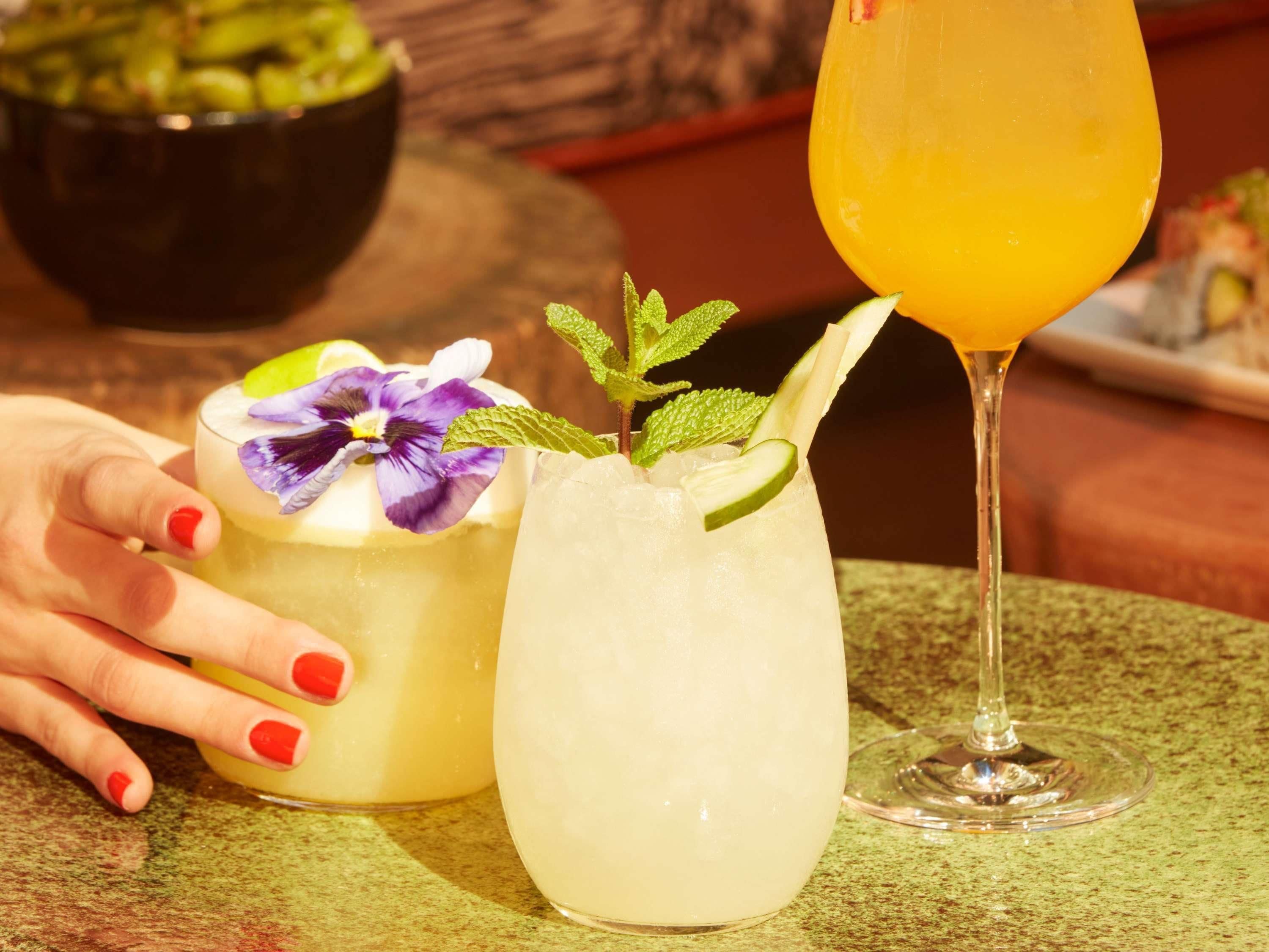 Deux boissons sur une table, une d’entre elles étant tenue par une main.