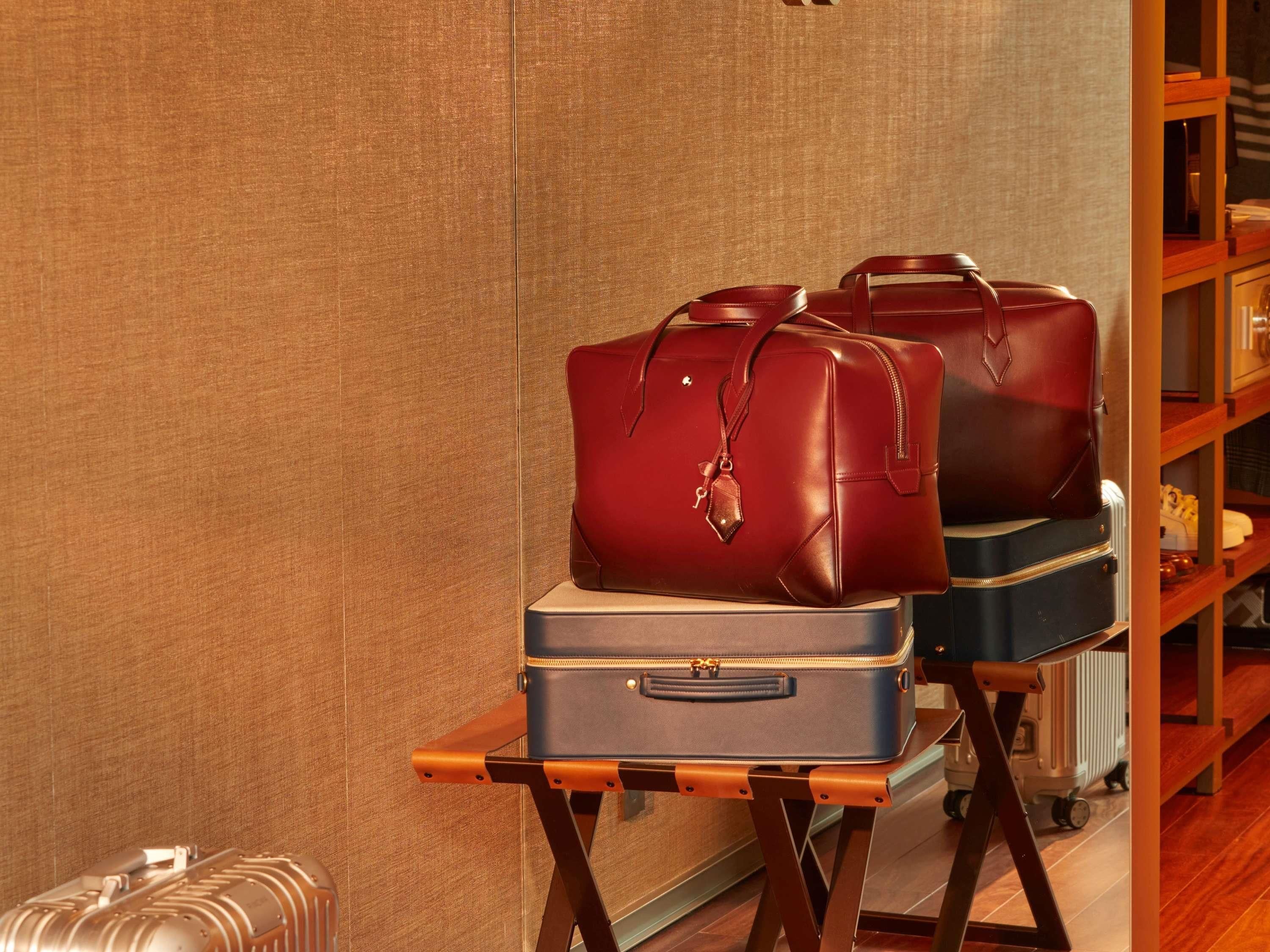 A luggage rack with two suitcases and a handbag.