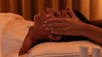 Une personne allongée, une main sur le visage, peut-être en train de recevoir un soin du visage.