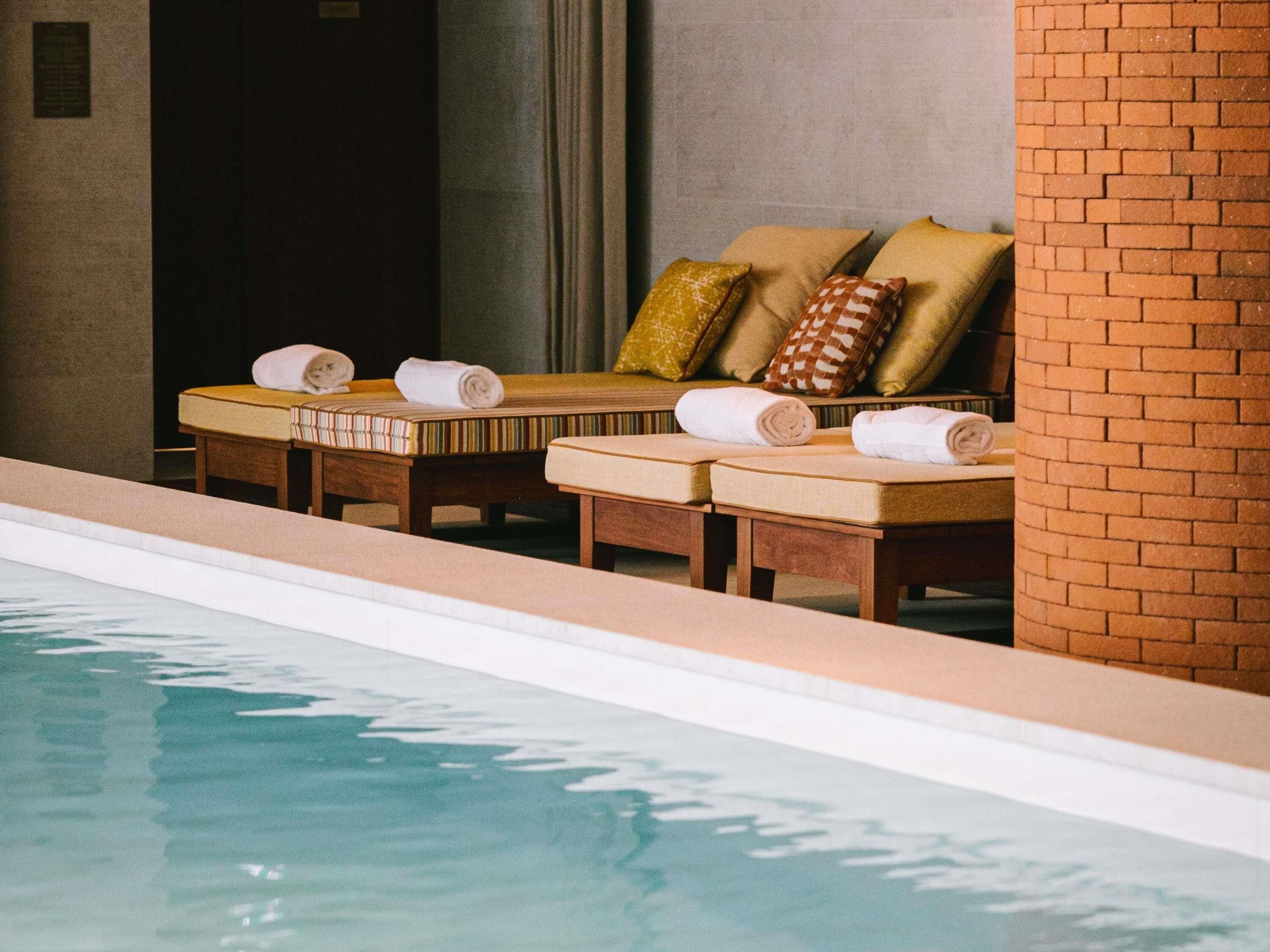 Una piscina techada, sillones reclinables de piscina