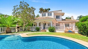 Une maison à deux étages avec une piscine à l’avant.