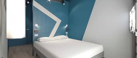 Une chambre d’hôtel moderne, équipée d’un lit, d’un bureau et d’une chaise.