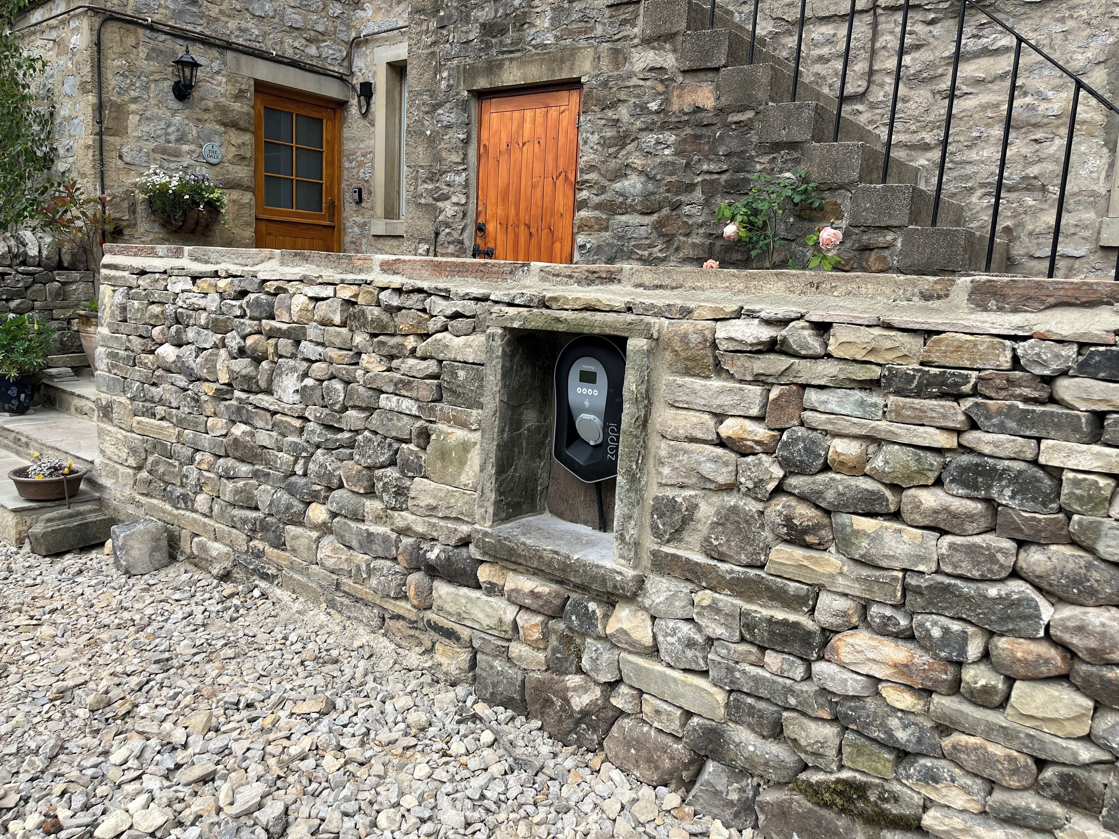 A stone building with a wooden door and a keypad entry.