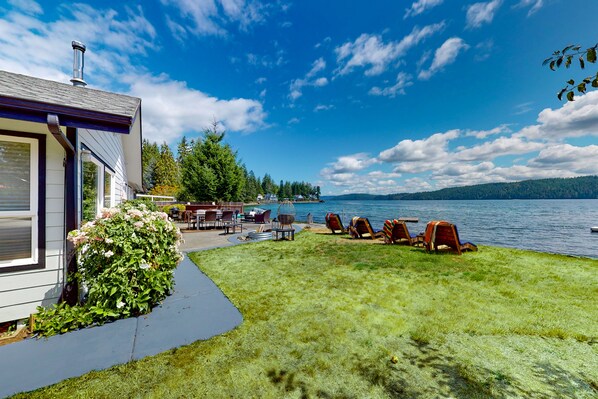 A lakeside property with a patio, outdoor seating, and a view of the lake.