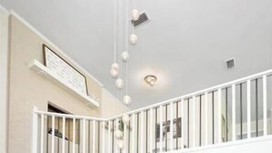 Un salón amplio con un sofá gris, una mesa de centro de madera y una chimenea.