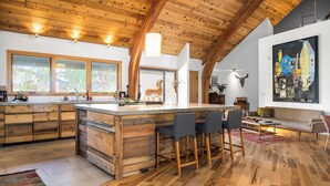 A spacious kitchen with a wooden island, large windows, and a modern art piece on the wall. - Stunning Repurposed Church, lofted, pet friendly, Free Botanic Garden admit 6 (Denver)