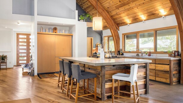 A modern kitchen with a large island, wooden ceiling, and a view of the outdoors. - Stunning Repurposed Church, lofted, pet friendly, Free Botanic Garden admit 6 (Denver)