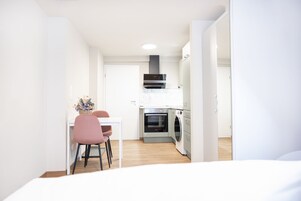 Uma cozinha moderna com área de jantar, incluindo uma mesa e cadeiras, e uma máquina de lavar roupa.