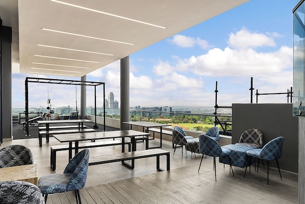 Relax and take in the city views from this serene outdoor space, featuring comfortable seating and a lush park view.