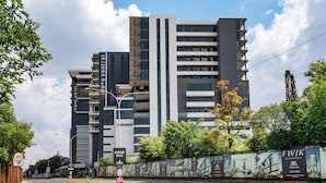 A modern multi-story building with a prominent 'Oxford Road' sign, surrounded by greenery and a clear sky. - Illovo Central 1023 (Sandton)