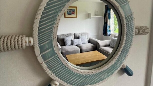 A round mirror with a nautical theme, mounted on a wall. - Villa 19 Lanteglos 2 bed sleep 5 (Lanteglos)