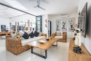 Relax in a stylish living area with a central coffee table, two sofas, and a large flat-screen TV.
