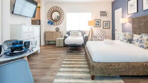A modern hotel room with a large bed, a desk with a computer, a TV, and a decorative mirror. - PRAIA Hotel Boutique Miami Beach (Miami Beach)