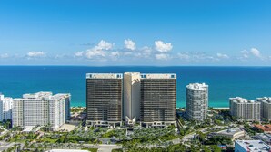 A high-rise hotel with a central atrium, multiple floors, and a view of the ocean. - PRAIA Hotel Boutique Miami Beach (Miami Beach)
