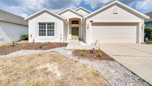 A two-story house with a garage, a front porch, and a landscaped front yard. - 10 Mi to Disney: Home w/ Spa & Heated Pool! (Davenport)