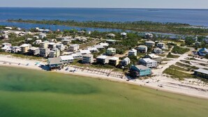 Eine Vogelperspektive eines Wohngebiets an der Küste mit Häusern, einem Strand und einer Marina.