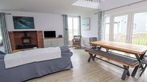 A modern living room with a sofa, a wooden table, and a fireplace. - Turning Tide (Chathill)