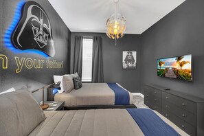 Relax in a serene bedroom with a large bed, Star Wars-themed mural, and a flat-screen TV.