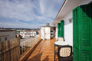 A balcony with a tiled floor, a washing machine, and a table with chairs.