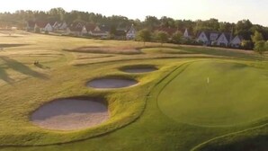 A golf course with bunkers and a flagstick. - Small house in cozy village near the sea (Ystad)