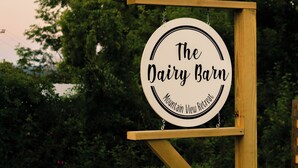 Letrero para 'The Dairy Barn Mountain View Retreat', con marco de madera y diseño circular.