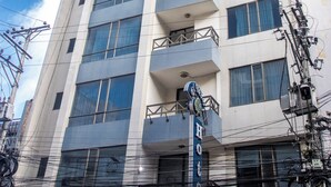 Et hotel med moderne design, med en buet glasfacade og flere balkoner.