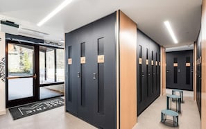 A hallway with lockers, a door with a number, and a small table with chairs. - Charlie Rentz: Penthouse Ski-In/Out, Sleeps 10, Pool + Waterslide, Snowmass Base Village (Snowmass Village)