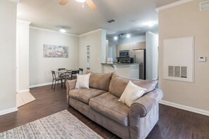 Relax in this stylish living room with a sofa, dining area, and kitchenette.