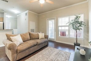 Relax in this spacious living room with a comfortable sofa, coffee table, and potted plant.