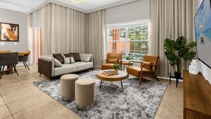 A modern living room with a sofa, armchairs, a coffee table, and a large window with curtains. - 4 BD/ 3 BA/ Paradise Palms (2955 BP) (Kissimmee)