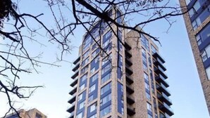 Un edificio de gran altura con varios pisos, ventanas amplias y balcones.