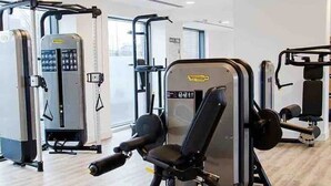 Un gimnasio con diversas máquinas de ejercicio, incluyendo una prensa de piernas y una de pecho.