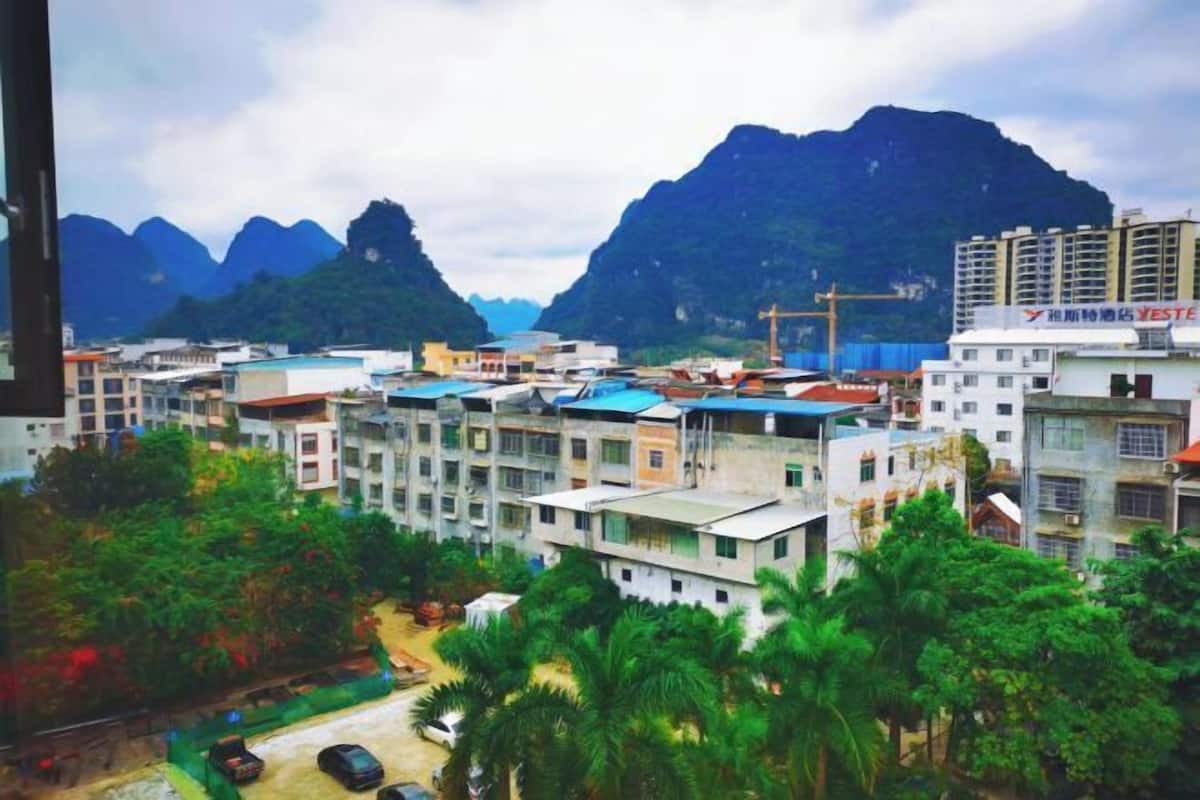 A residential area with multi-story buildings, a construction site, and mountains in the background.