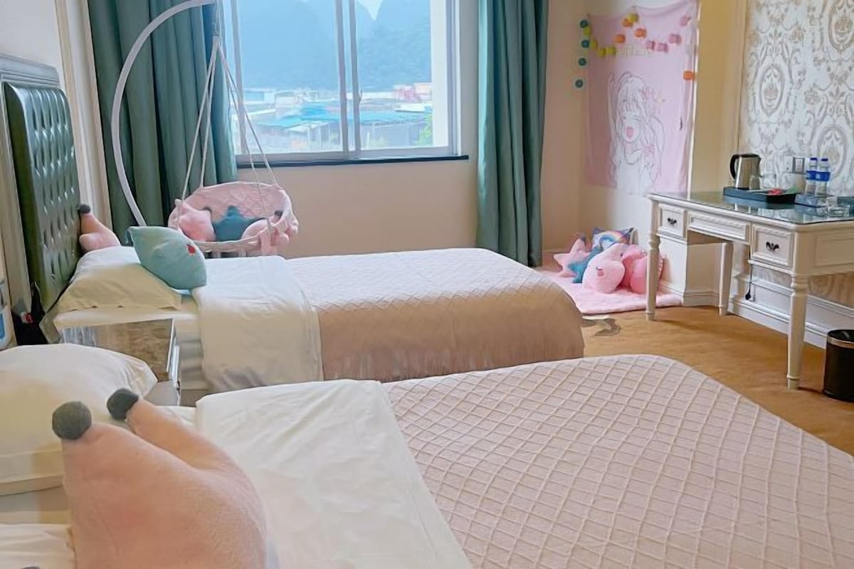 Ein Hotelzimmer mit zwei Betten, einem Schreibtisch und Blick auf die Berge.