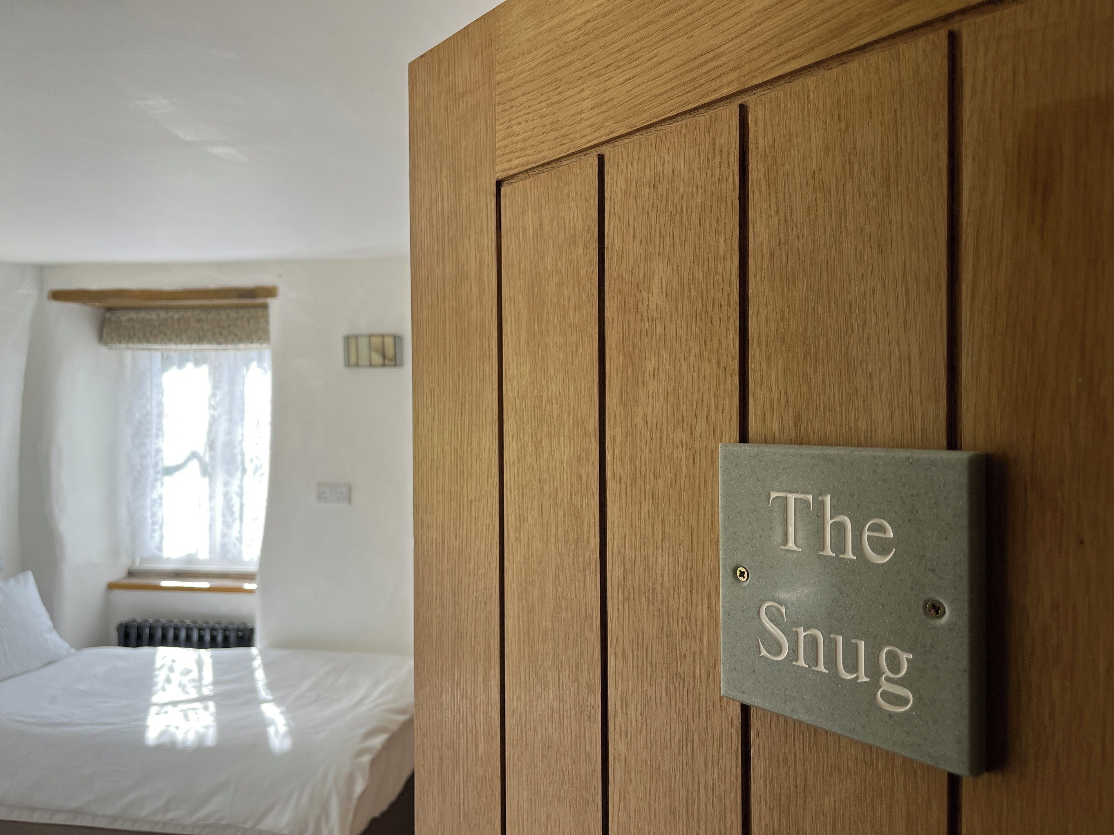 En trædør med et skilt, der siger "The Snug".