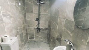 A bathroom with a toilet, bidet, sink, and a shower. - Edo Evleri (Mardin)