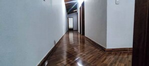 Un pasillo con suelo de madera y paredes blancas.
