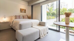 A modern bedroom with a bed, a sofa, a bedside table, and a view of the outside. - Charlie Onze22 Vila Madalena (São Paulo)