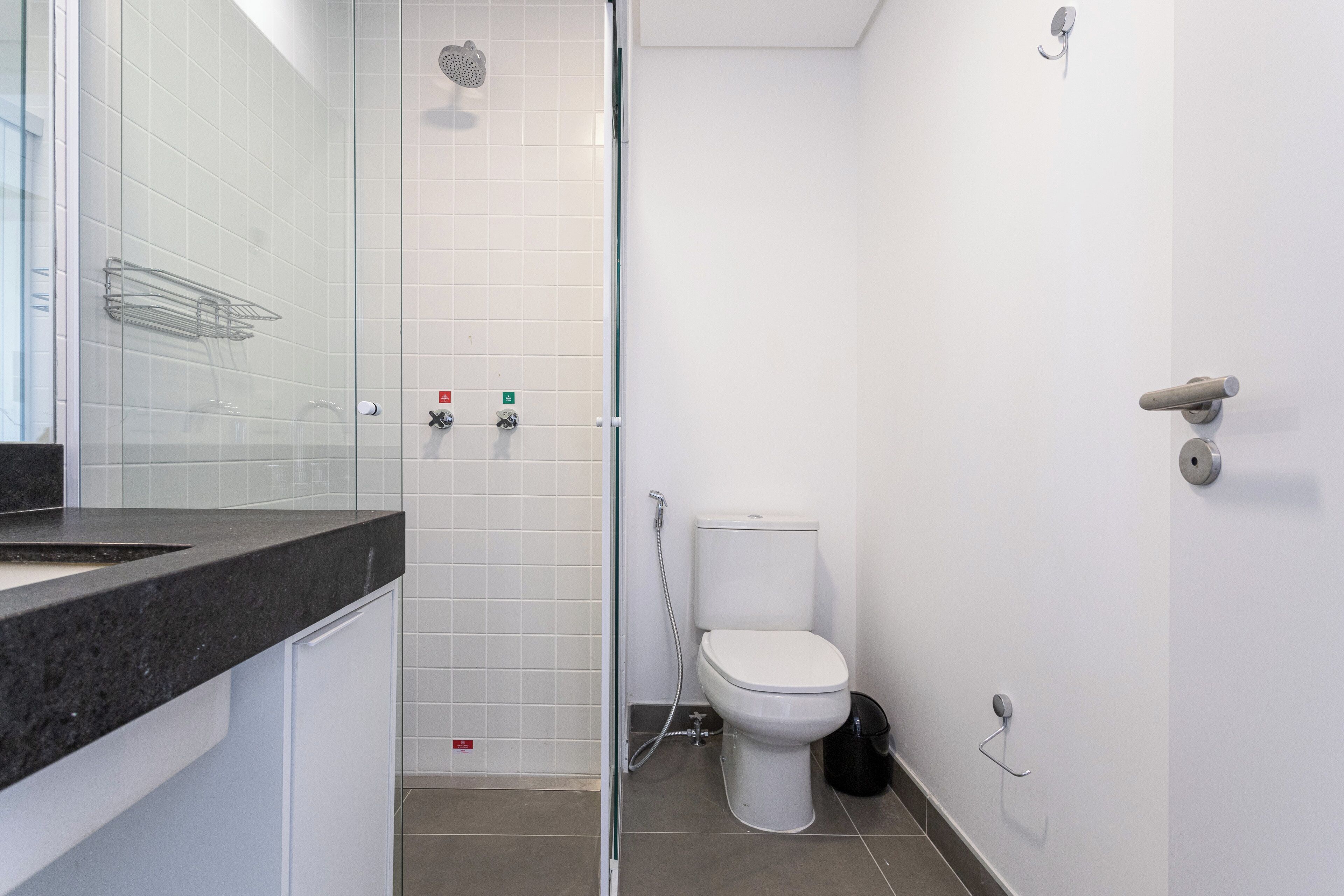 A modern bathroom with a shower, toilet, and sink.