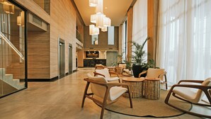 En rummelig lobby med moderne møbler, en trappe og et receptionsområde.