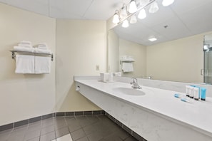 A hotel bathroom with a large sink, two towel racks, and a mirror. - Bayshore Resort (Put-in-Bay)