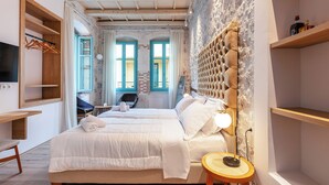 Ein Schlafzimmer mit einem großen Bett, einem Holzkopfteil und einem kleinen runden Tisch mit einer Lampe.