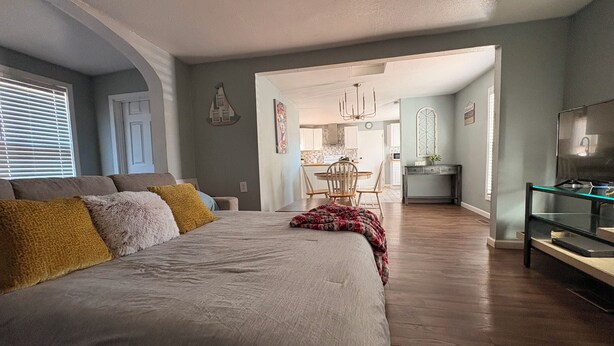 A bedroom with a large bed, a dining area, and a TV. - Cheerful Bronson Cutie
 (Bronson)