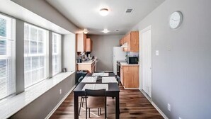 A compact kitchen with wooden cabinets, a microwave, and a refrigerator. - 4 bed/ 2 bath gem
 (Killeen)