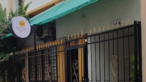 A hostel with a green awning, a signboard, and a gated entrance. - alborada hostel B&B  (Santa Marta)