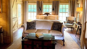 A cozy room with a bed, a sofa, a small table, and a suitcase. - Romantic Secret Cottage near downtown Carthage (Carthage)