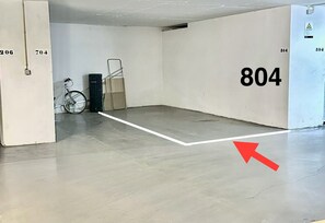 A room with a grey floor, white walls, and a large number '804' on one wall. A red arrow points to a crack on the floor. - Seaview Luxury Apartment A/c Wi-Fi garage (Portimão)