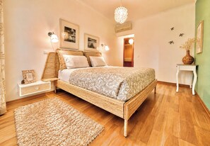 A bedroom with a bed, bedside tables, a rug, wall art, and a hanging light fixture. - Seaview Luxury Apartment A/c Wi-Fi garage (Portimão)